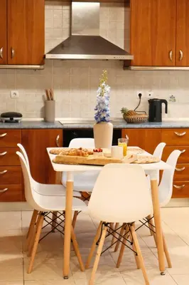 a kitchen with a table with white chairs and a counter at KMS Summer House Ialisos in Rhodes Town
