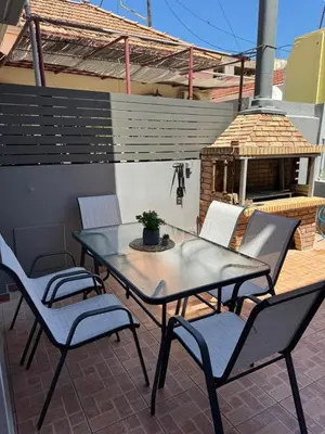 a table and chairs on a patio with a fireplace at KMS Summer House Ialisos in Rhodes Town
