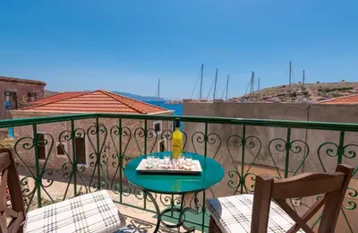 a table with a vase on top of a balcony at Matina's House in Halki
