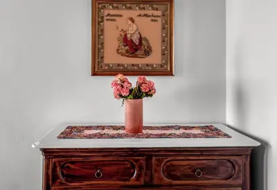 a vase of flowers sitting on top of a dresser at Matina's House in Halki