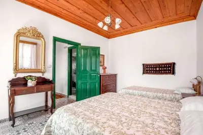 a bedroom with two beds and a table and a mirror at Matina's House in Halki