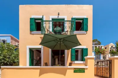 a green umbrella in front of a building at Matina's House in Halki