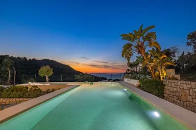 a swimming pool with a sunset in the background at Adamas Villa Rhodes in Rhodes Town