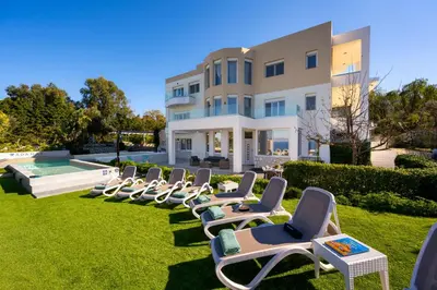a row of lawn chairs in front of a building at Adamas Villa Rhodes in Rhodes Town