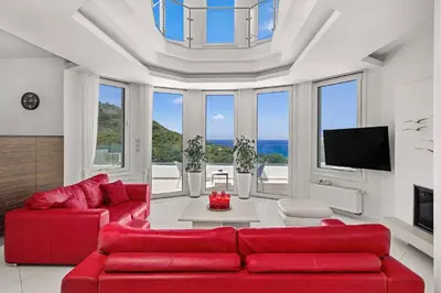 a living room with two red couches and a tv at Adamas Villa Rhodes in Rhodes Town