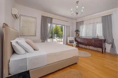 a bedroom with a large bed and a desk in it at Adamas Villa Rhodes in Rhodes Town