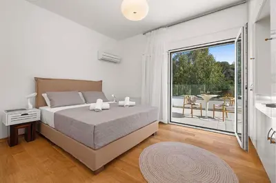 a bedroom with a large bed and a balcony at Adamas Villa Rhodes in Rhodes Town