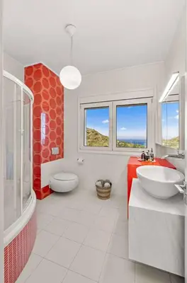 a bathroom with a sink and a toilet andwindows at Adamas Villa Rhodes in Rhodes Town
