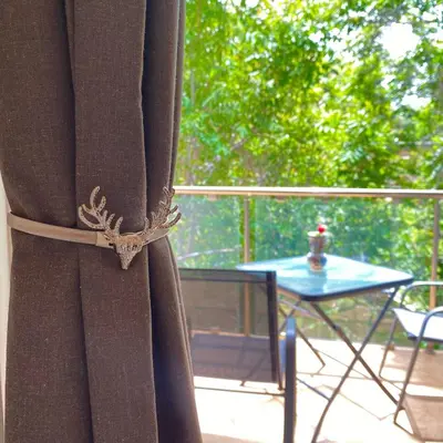 a curtain on a balcony with a table and a tableearcher at SEAL of Deer - Castle View - 5 minute walk to the Beach in Rhodes Town