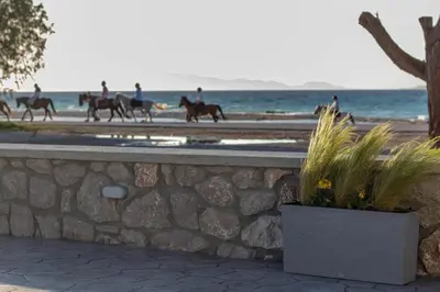 a group of people riding horses on the beach at Onda Blu in Rhodes Town