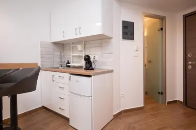 a kitchen with white cabinets and a sink at Gravity Downtown Balcony Studio in Rhodes Town