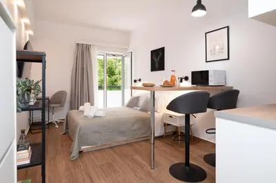 a bedroom with a bed and a desk in a room at Gravity Downtown Balcony Studio in Rhodes Town