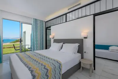a bedroom with a large bed and a view of the ocean at Sunrise Hotel in Pefki Rhodes