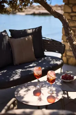 two wine glasses on a table next to a couch at Sunrise Hotel in Pefki Rhodes