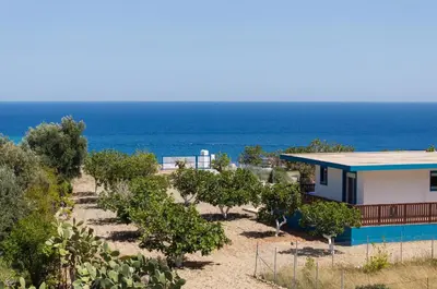 a house on the beach with the ocean in the background at Laftiras Sea View Home in Archangelos