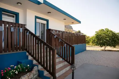a house with a staircase leading to a door at Laftiras Sea View Home in Archangelos