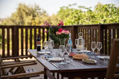 a wooden table with wine glasses and bread and flowers at Laftiras Sea View Home in Archangelos
