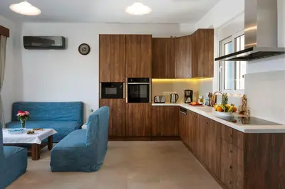 a kitchen with a blue couch and a blue chair at Laftiras Sea View Home in Archangelos