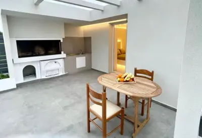 a dining room with a table and chairs and a television at White House Luxury Apartment of Rhodes in Kremasti