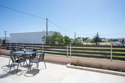 a table and chairs on a balcony with a fence at Twin Villas Gennadi in Gennadi