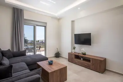 a living room with a couch and a flat screen tv at Twin Villas Gennadi in Gennadi