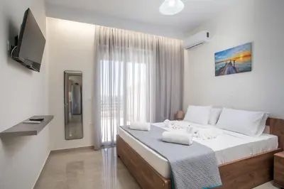 a bedroom with a large bed and a television at Twin Villas Gennadi in Gennadi