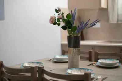 a table with plates and a vase with flowers at Twin Villas Gennadi in Gennadi