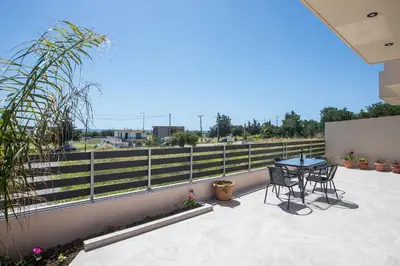 a patio with a table and chairs on a balcony at Twin Villas Gennadi in Gennadi