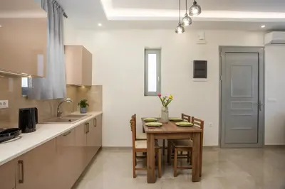 a kitchen with a wooden table with chairs and a tableasteryasteryasteryasteryastery at Twin Villas Gennadi in Gennadi
