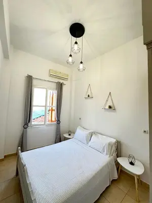 a bedroom with a white bed and a window at Seaside escape in Symi