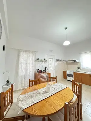 a kitchen and dining room with a wooden table and chairs at Seaside escape in Symi