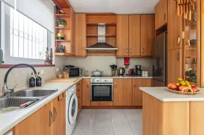 a kitchen with wooden cabinets and a sink at Terra Ventura Villa At The Hill in Triánta