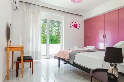 a bedroom with a large bed with pink cabinets at Terra Ventura Villa At The Hill in Triánta