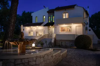 a house with a fountain in front of it at night at Terra Ventura Villa At The Hill in Triánta