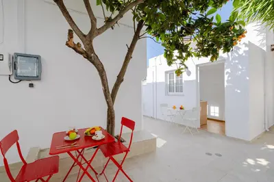 a red table and chairs next to a tree at Cleopatra's Backyard in Rhodes Town
