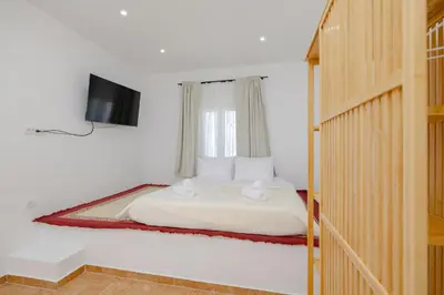 a bedroom with a bed with a tv on the wall at Cleopatra's Backyard in Rhodes Town