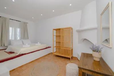 a white bedroom with a bed and a window at Cleopatra's Backyard in Rhodes Town