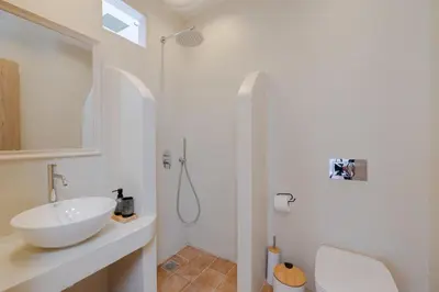 a white bathroom with a sink and a shower at Cleopatra's Backyard in Rhodes Town