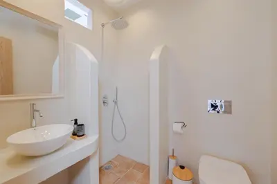 a white bathroom with a sink and a shower at Cleopatra's Backyard in Rhodes Town