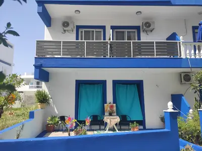 a blue and white house with a balcony at Apollon Stegna Studios in Archangelos