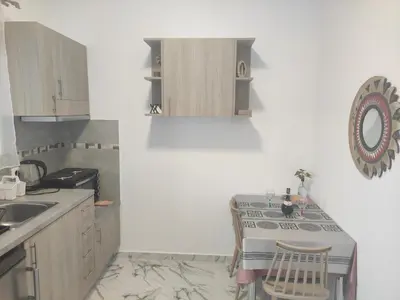 a kitchen with a sink and a table with chairs at Apollon Stegna Studios in Archangelos