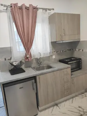 a kitchen with a sink and a microwave at Apollon Stegna Studios in Archangelos