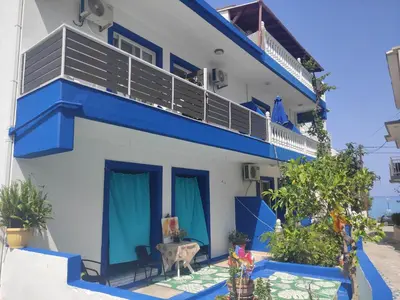 a blue and white building with a balcony at Apollon Stegna Studios in Archangelos