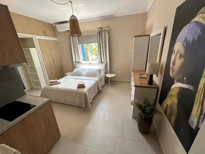 a bedroom with a bed and a painting of a woman at Katalyma Thalassa in Ixia