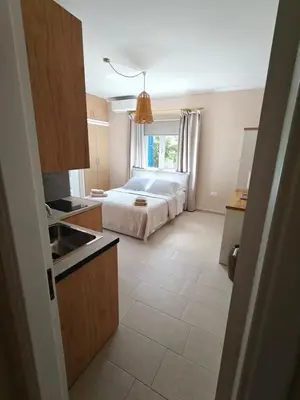 a bedroom with a bed and a kitchen with at Katalyma Thalassa in Ixia