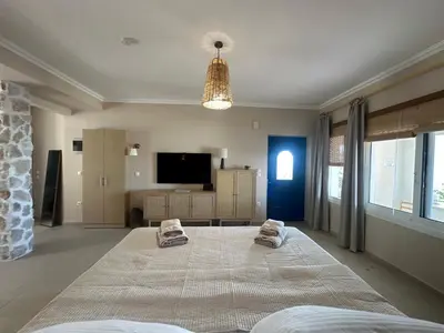 a bedroom with a large bed and a tv at Katalyma Thalassa in Ixia