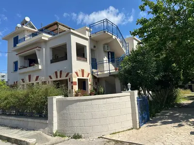a white house with a fence in front of it at Katalyma Thalassa in Ixia