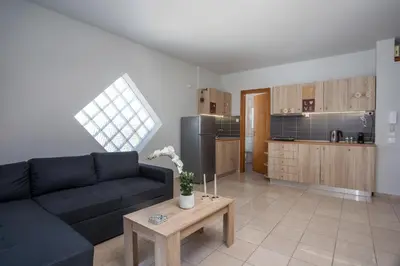 a living room with a couch and a kitchen at DownTown Horizon View in Rhodes Town