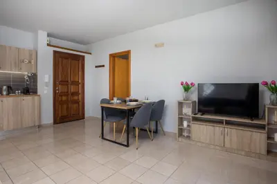 a living room with a table and a flat screen tv at DownTown Horizon View in Rhodes Town