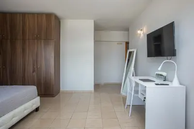 a bedroom with a bed and a desk and a tv at DownTown Horizon View in Rhodes Town